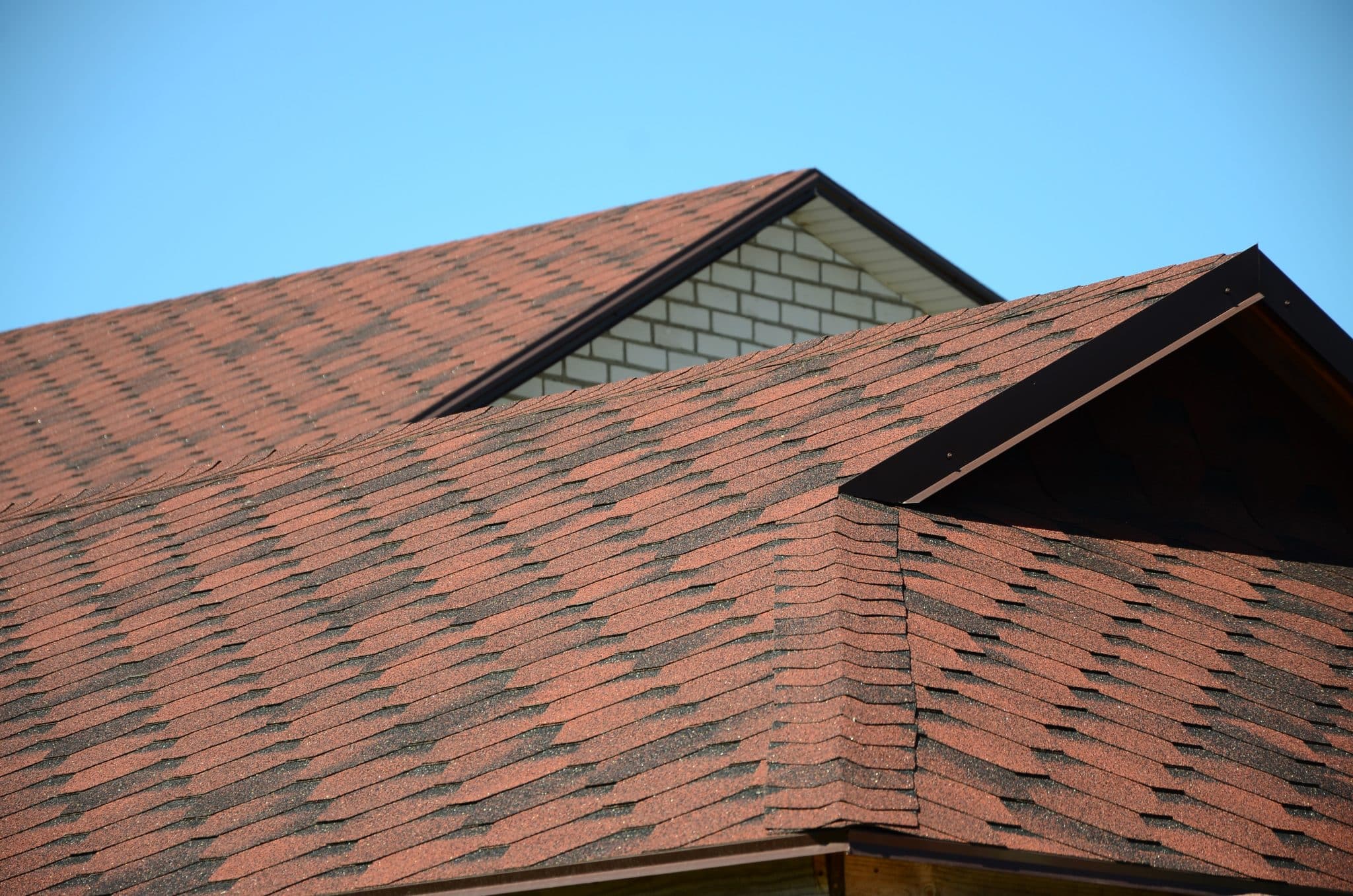 A roof covered with brown bituminous shingles.