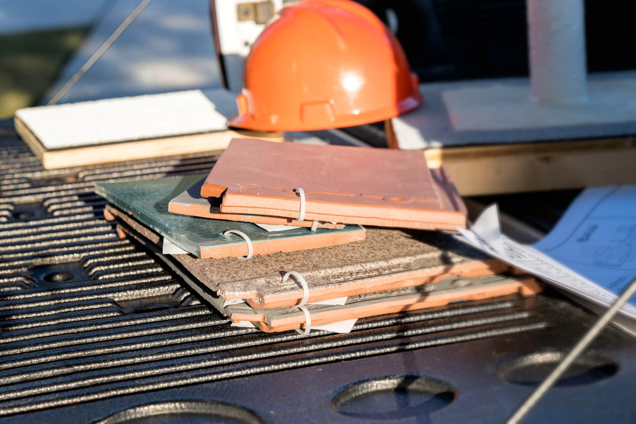Sample roofing materials and an orange hardhat in the bed of a pickup truck