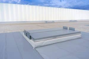 White metal sheet rooftop wall on commercial building with blue sky